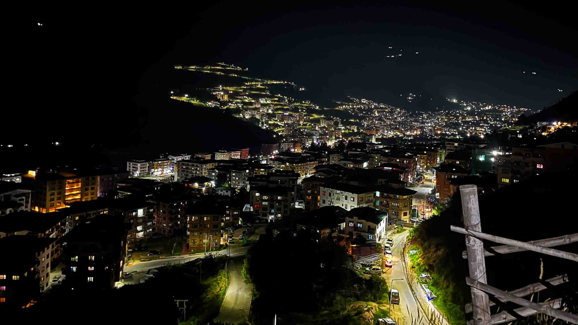 A city lit up by roads and houses at night.
