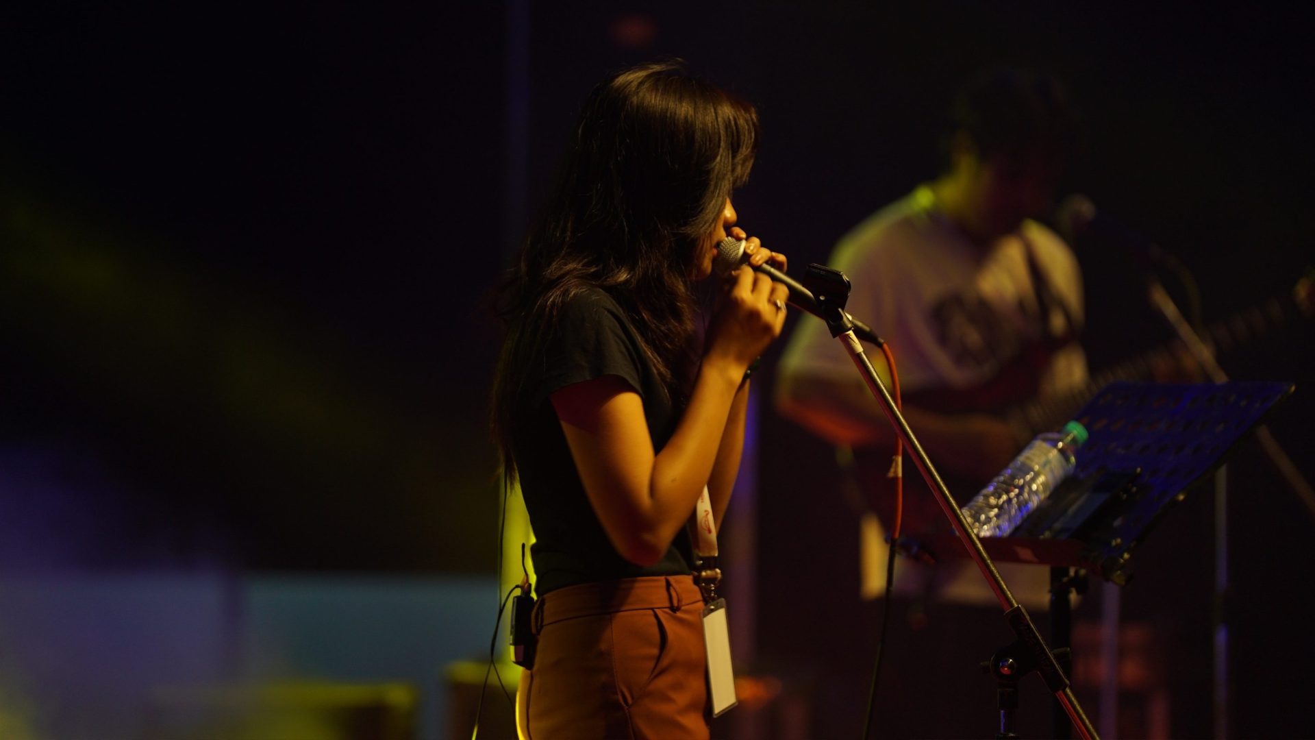 Woman sings into microphone.