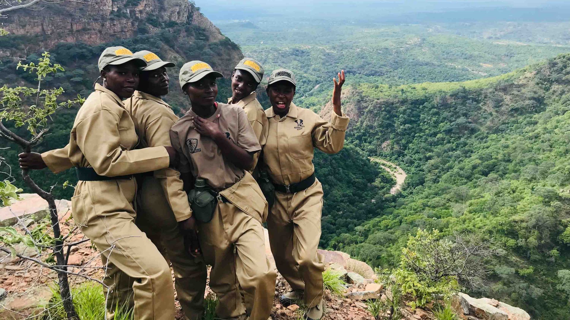Female rangers posing on a cliffside.