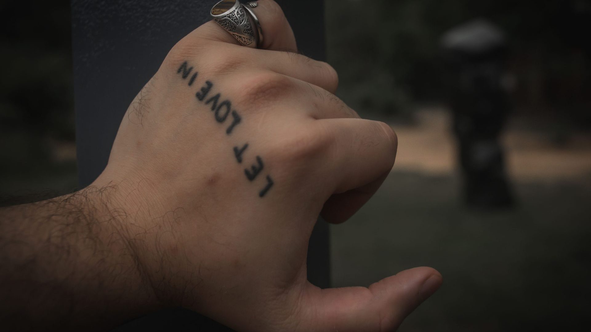 Hand with tattoo reading: Let Love In