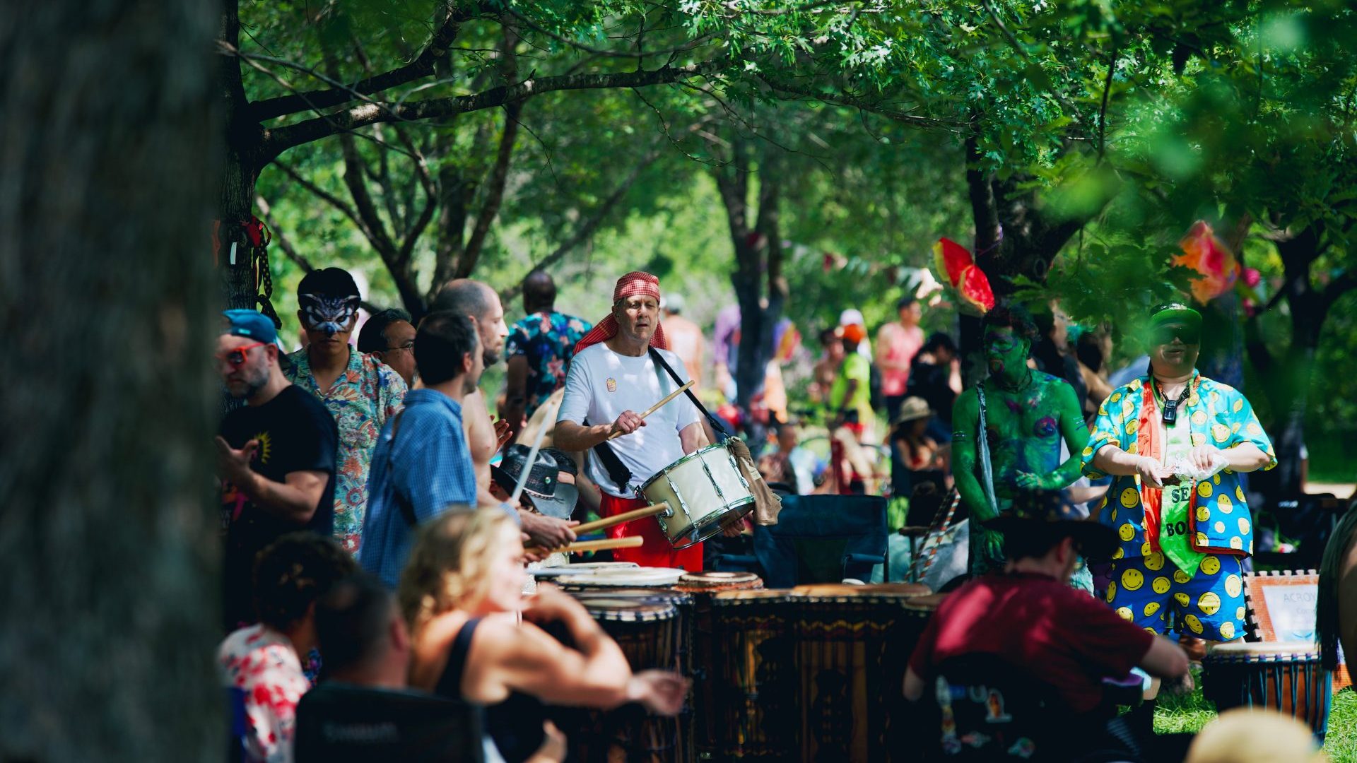 Group of men play drums and percussive instruments.