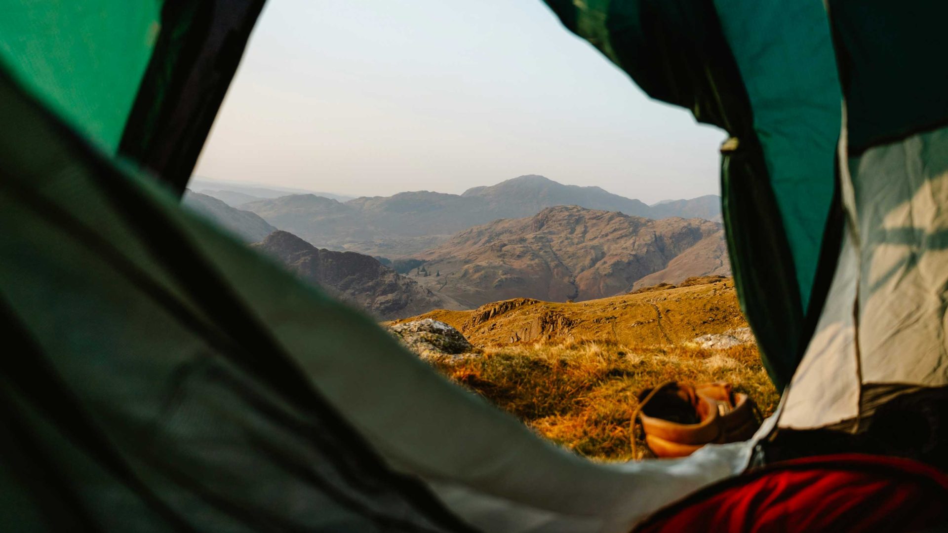 Looking out a tent door at hills in the distance.