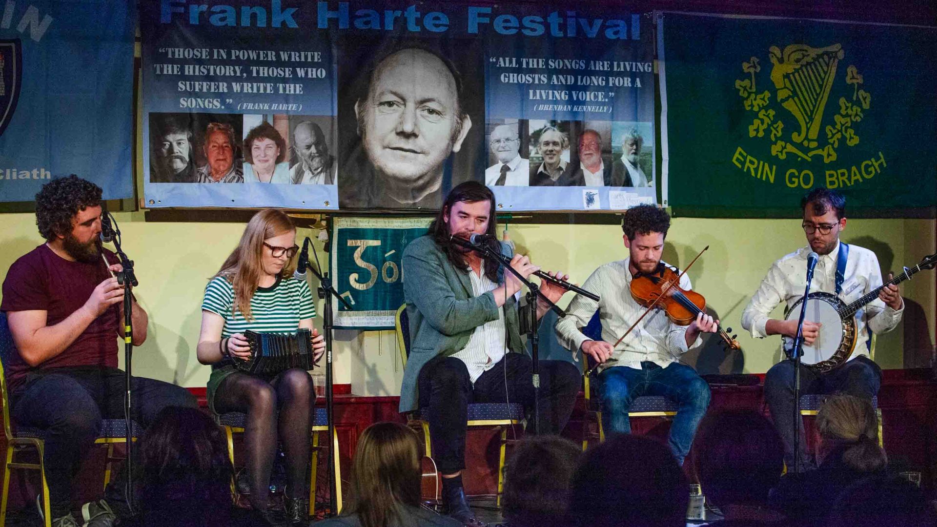 Five people play instruments on stage.
