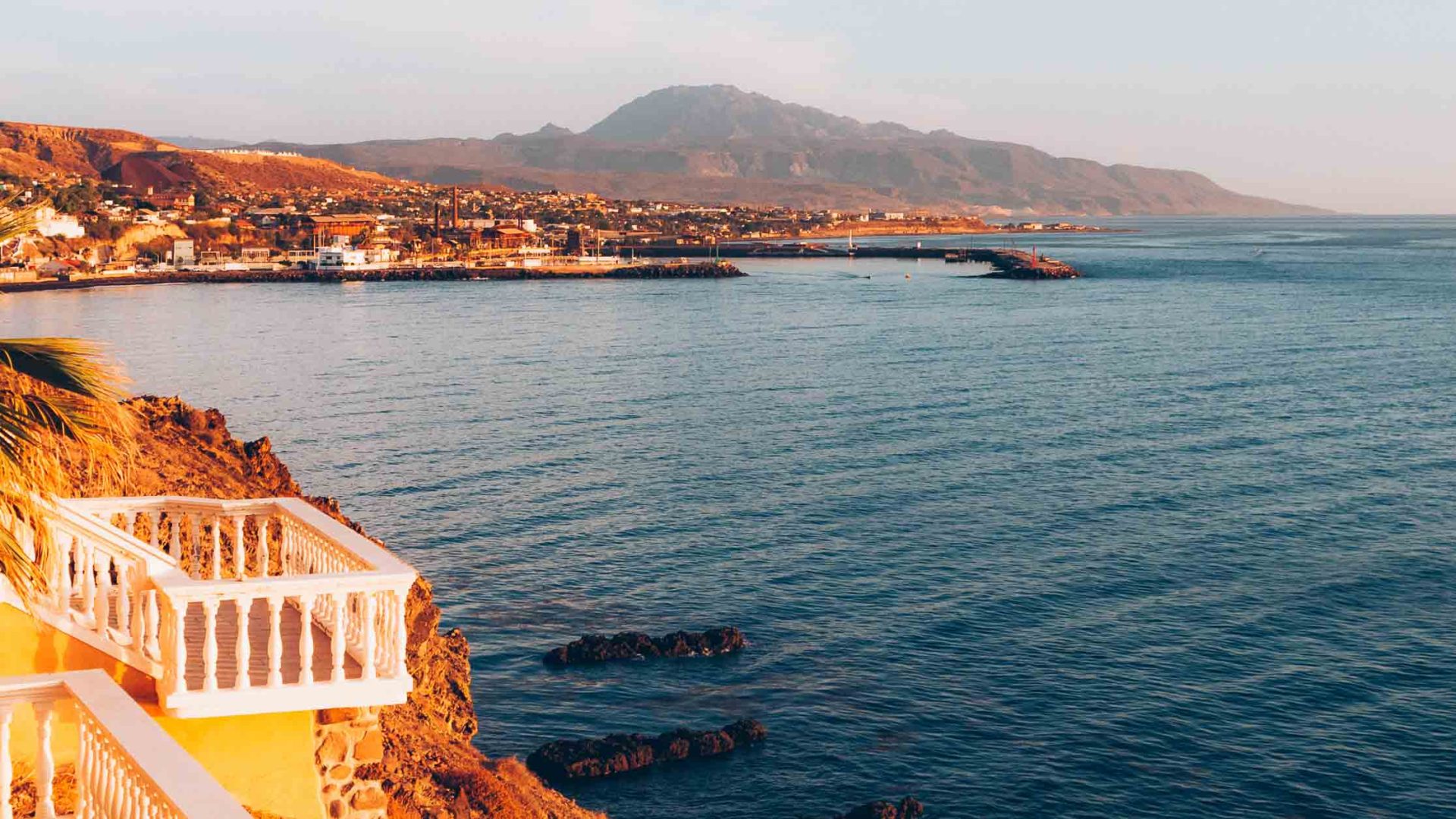 The sun is soft on a small town on the edge of blue sea.