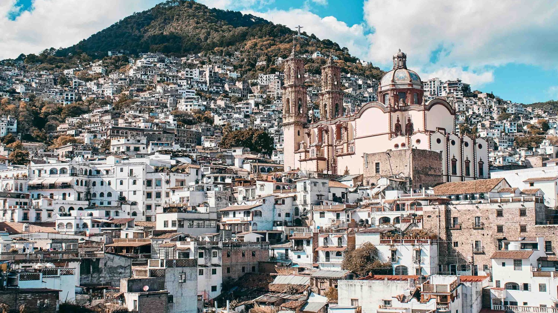 A town in hills with many white buildings and a prominent church.