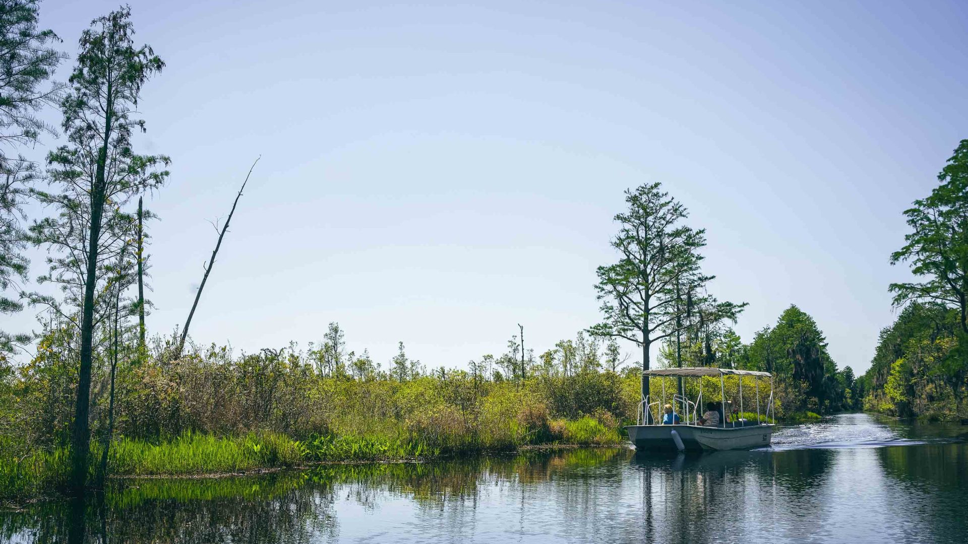 A covered boat makes its way down a waterway.