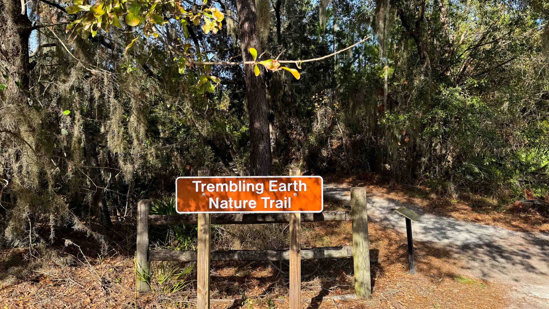 A sign by a nature trail that reads "Trembling Earth Nature Trail".