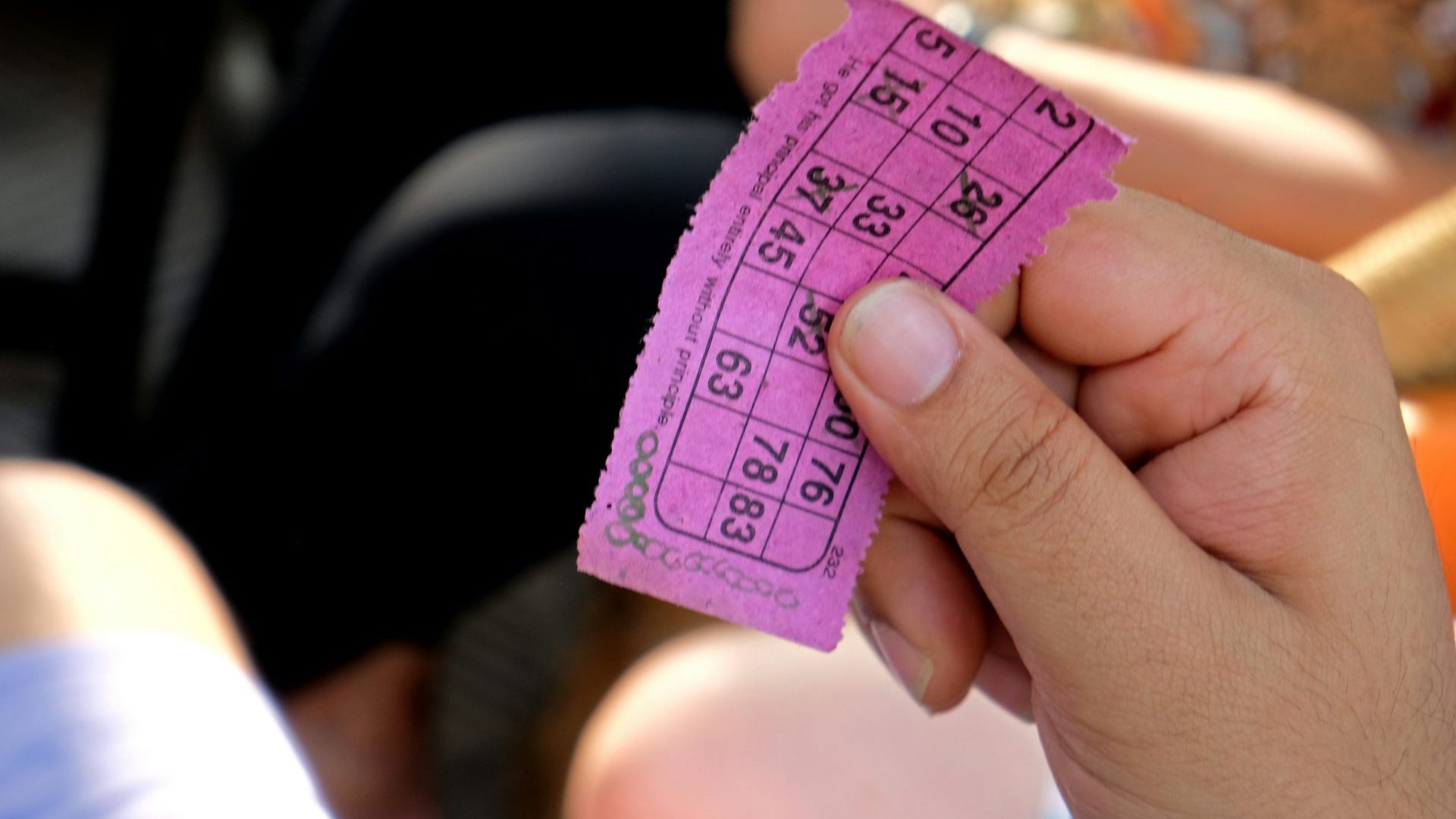 Hand holds pink bingo ticket