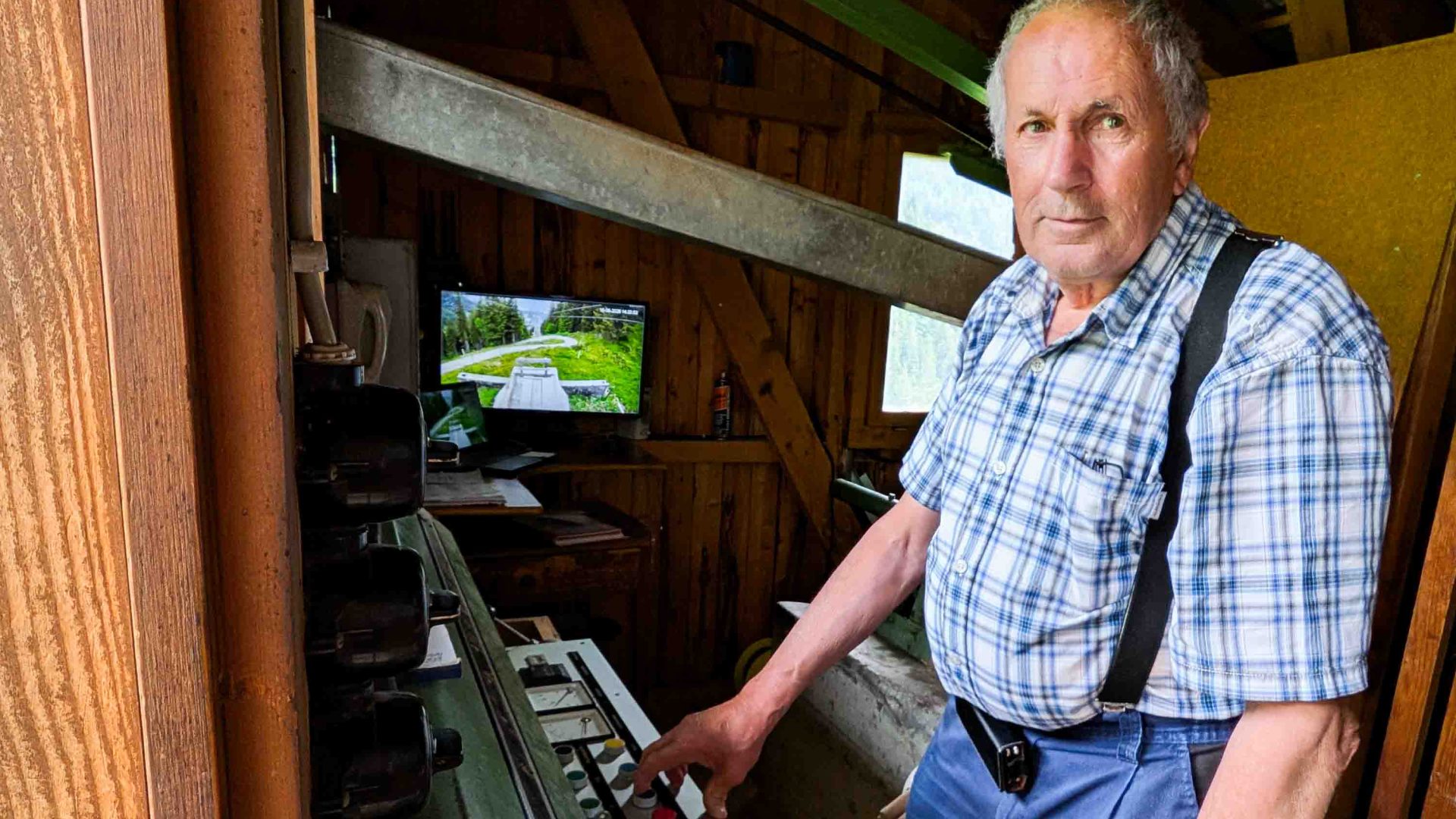 A man in a chequered shirt operates a switchboard.