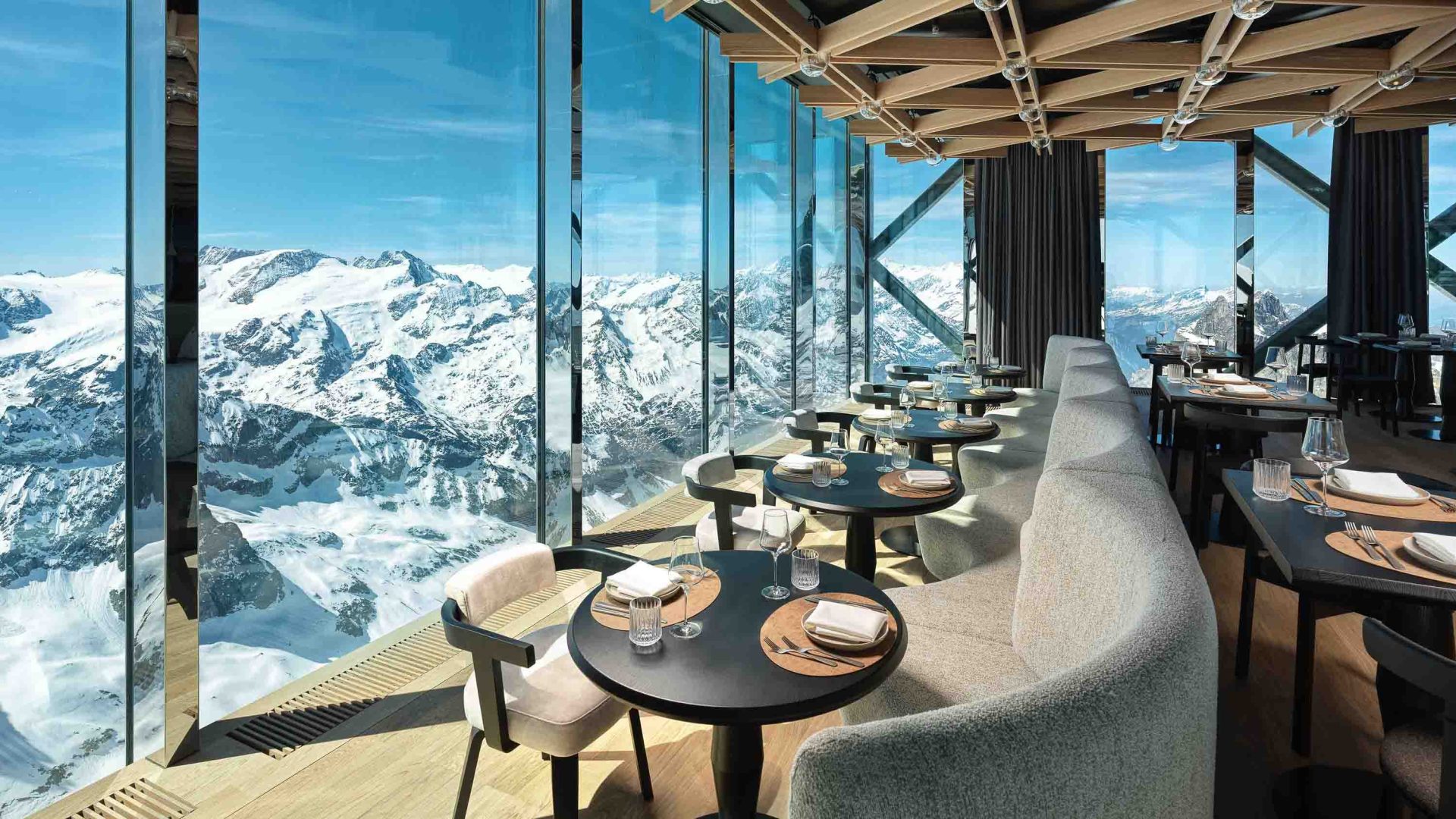 A restaurant with windows looking out at snowy mountains.