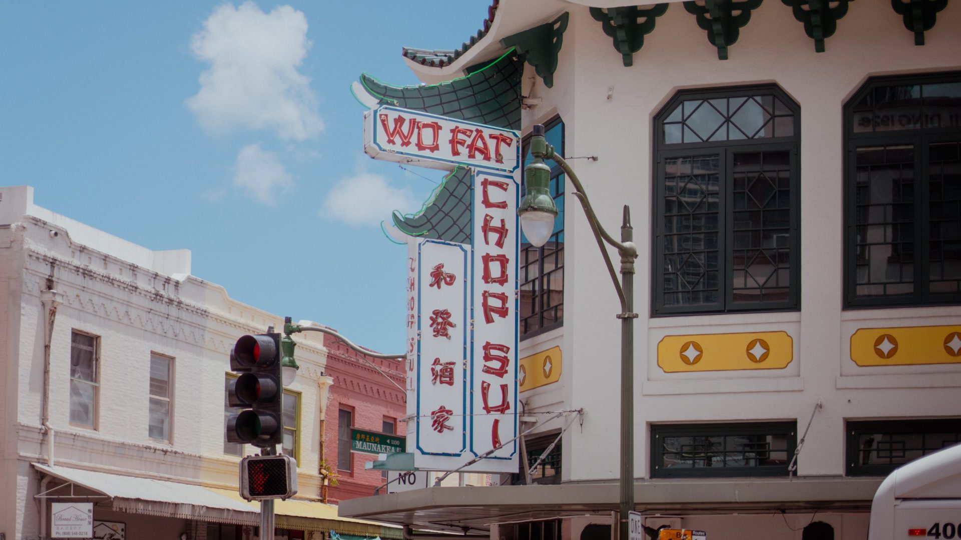 White and green building with sign reading "Wo Fat Chop Sui"