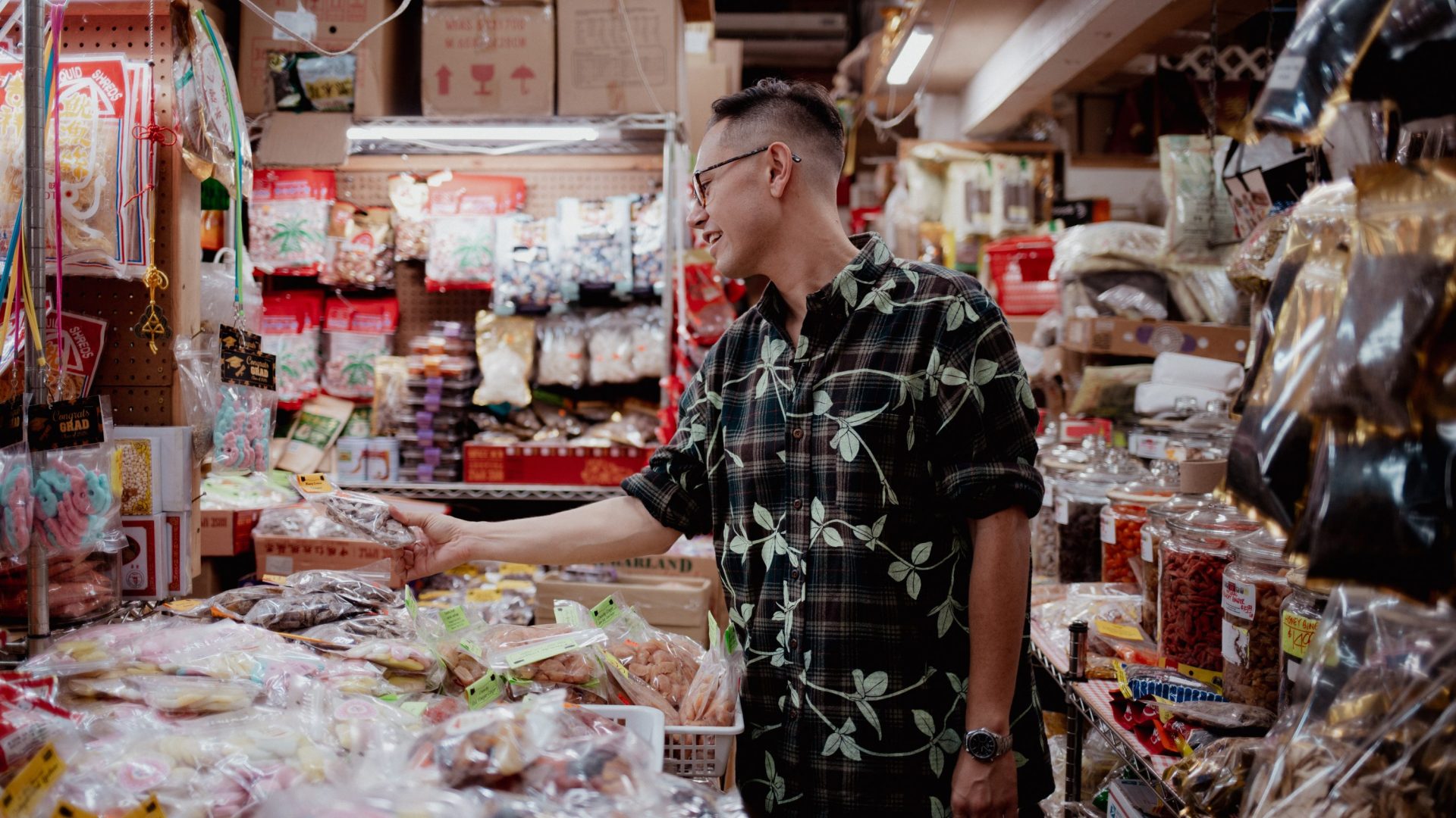 Man in floral shirt peruses items for sale inside a Chinese grocery store