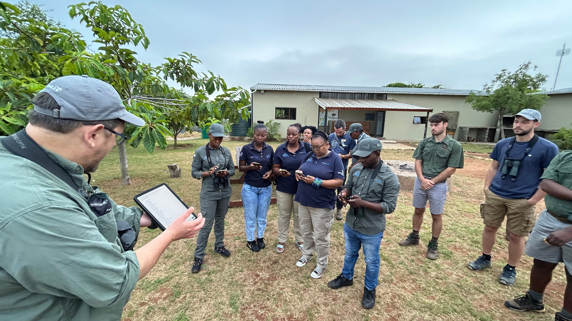 A group gather outside for sound recording workshop.