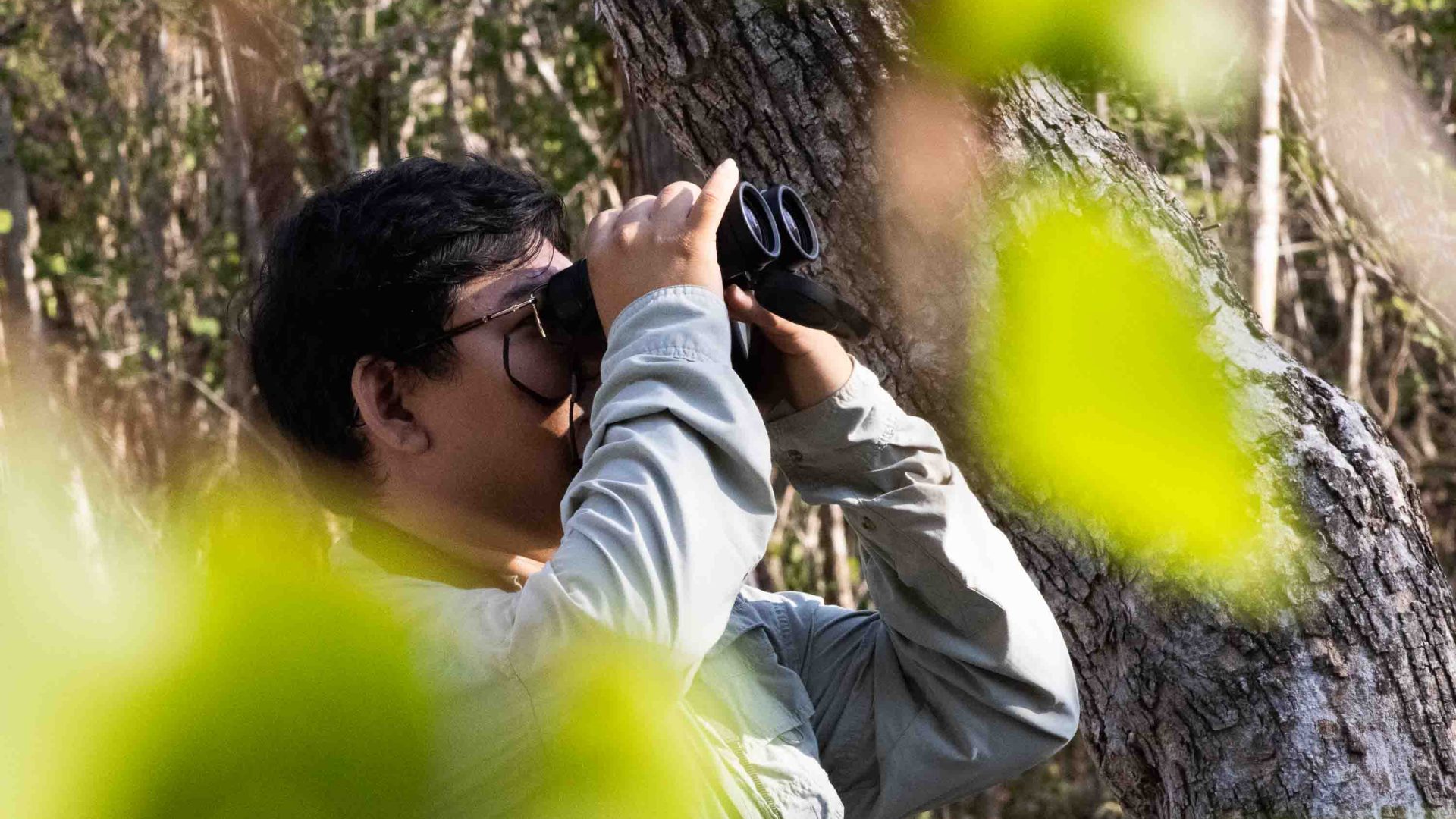 A man looks through binoculars.