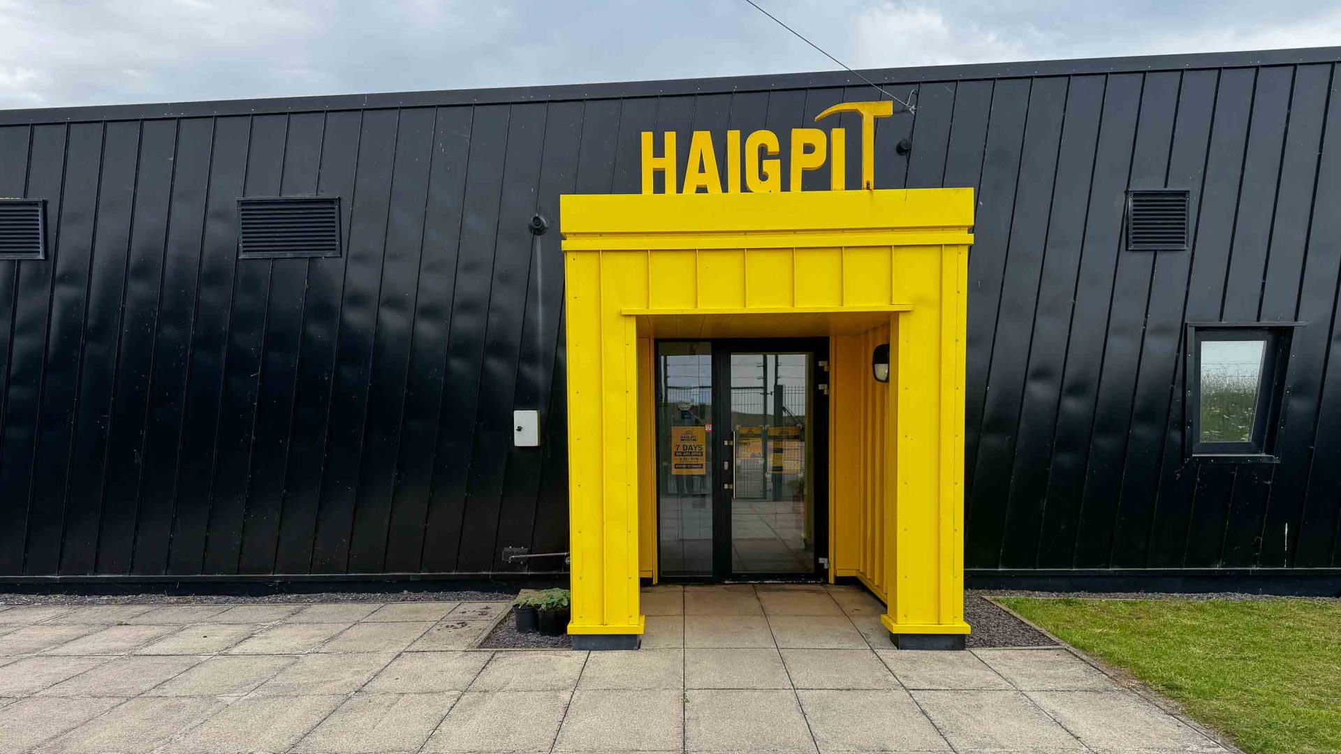 A black and yellow exterior of a cafe.