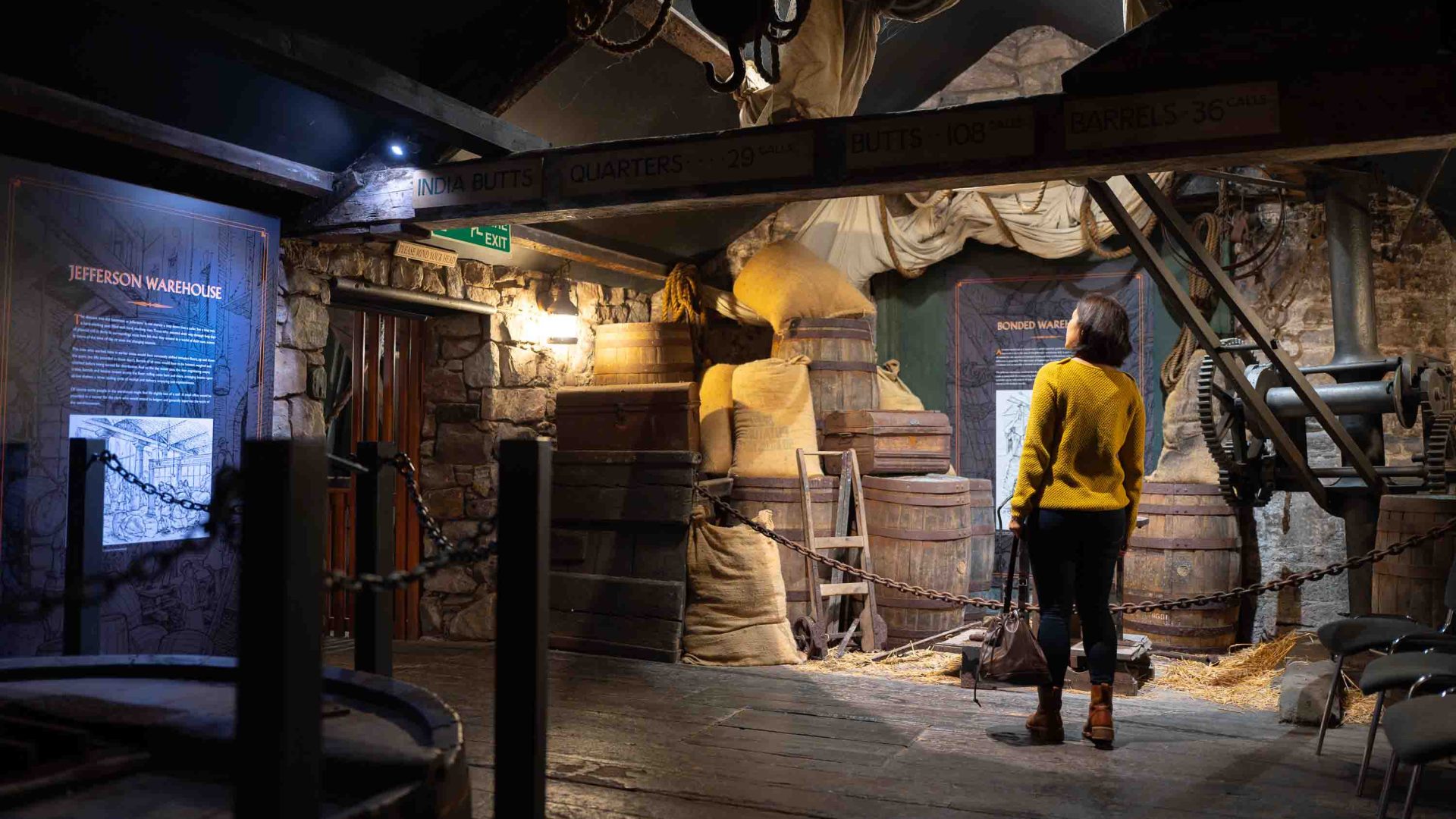 A woman looks at an exhibit in a rum museum.