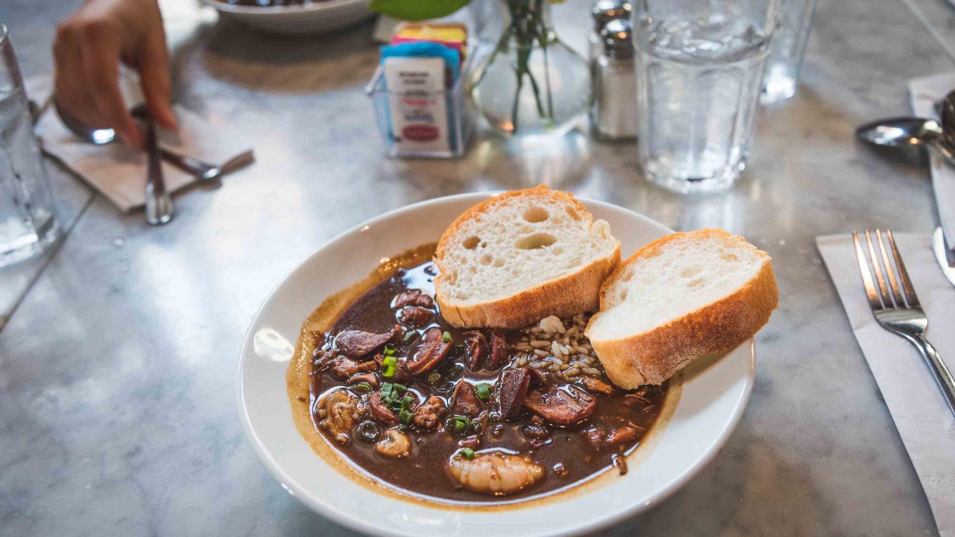 A plate of gumbo served with bread.