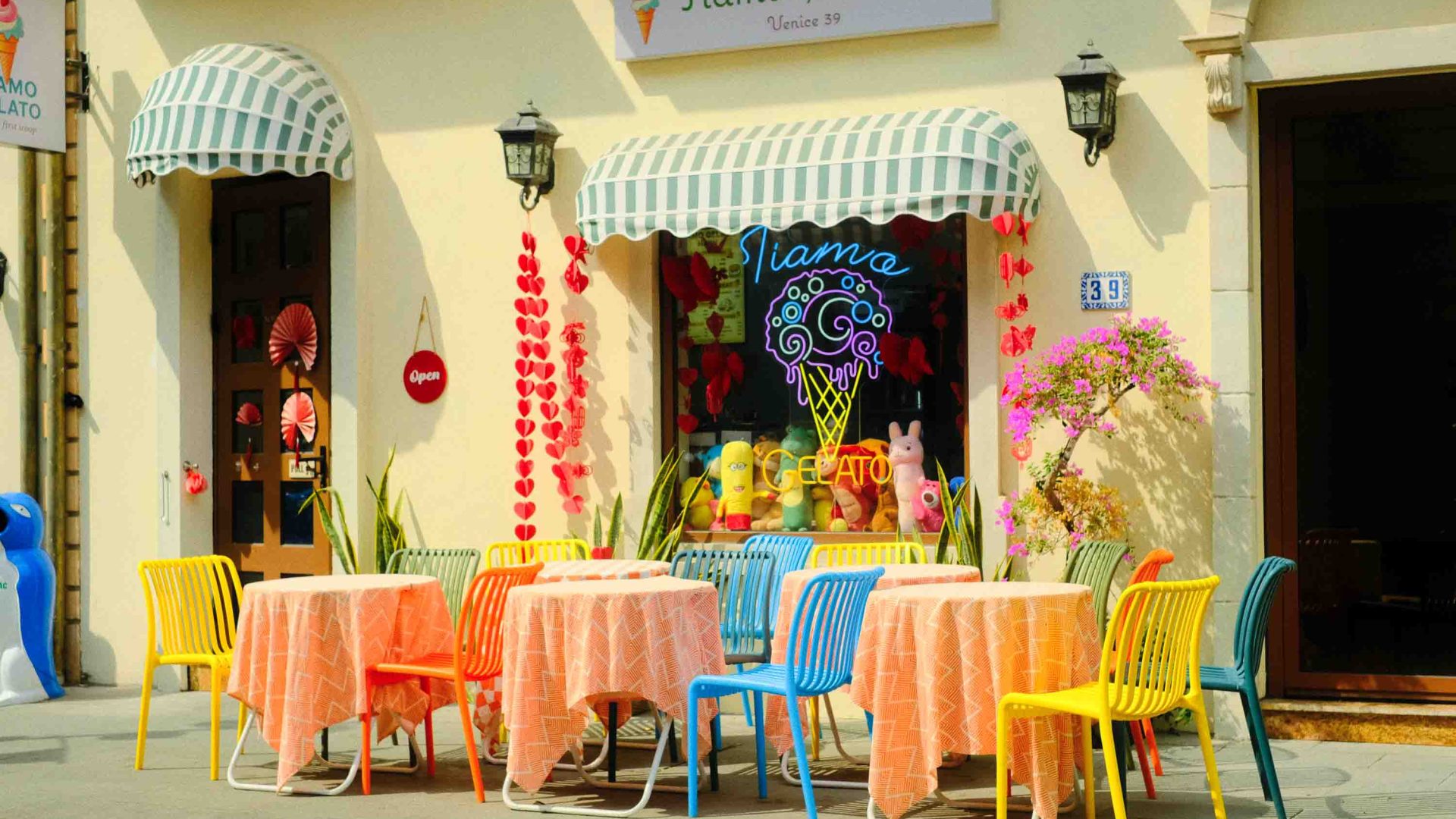 A colorful gelato shop with outside tables.