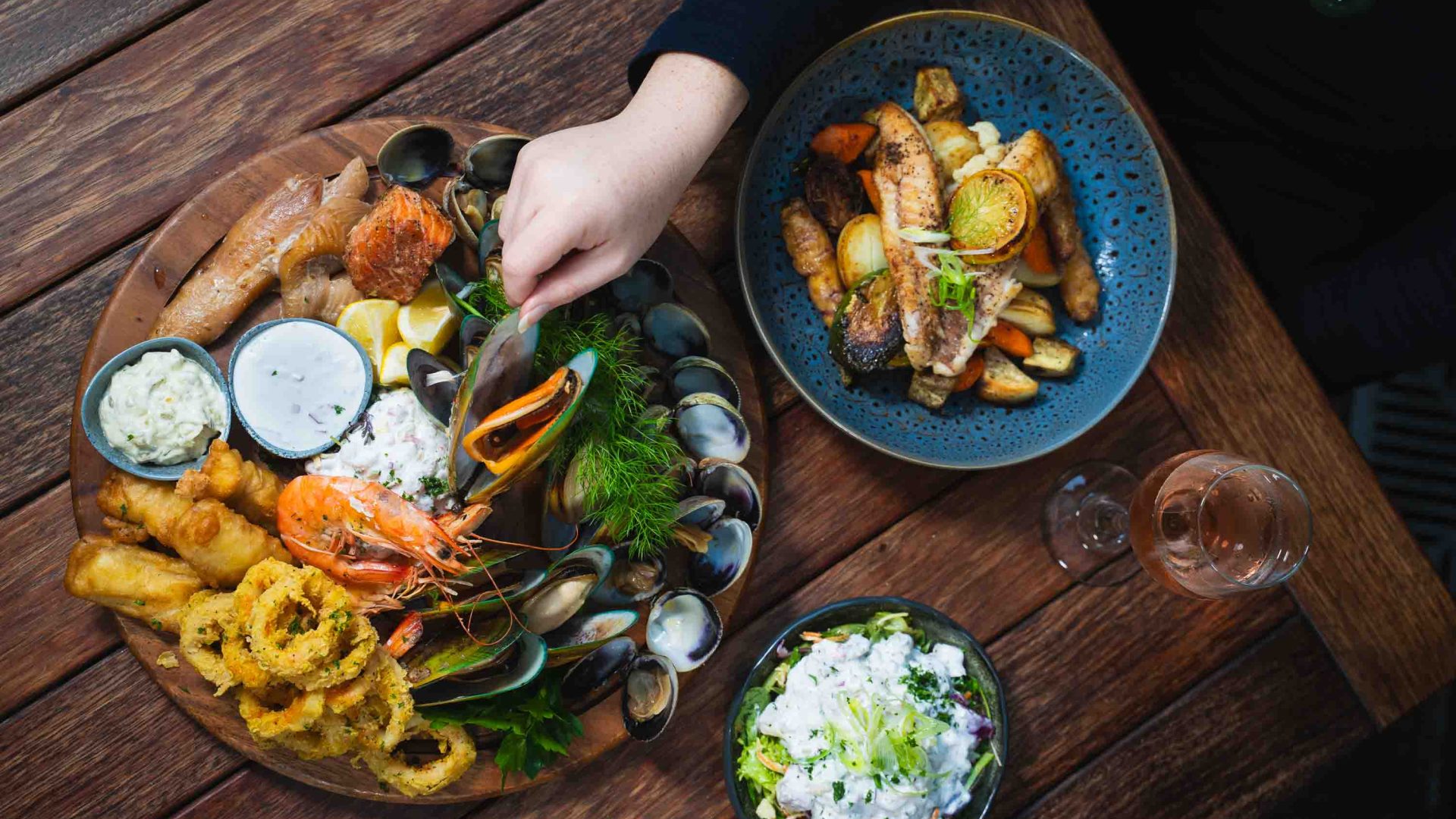 A person reaches out for a plate of food.