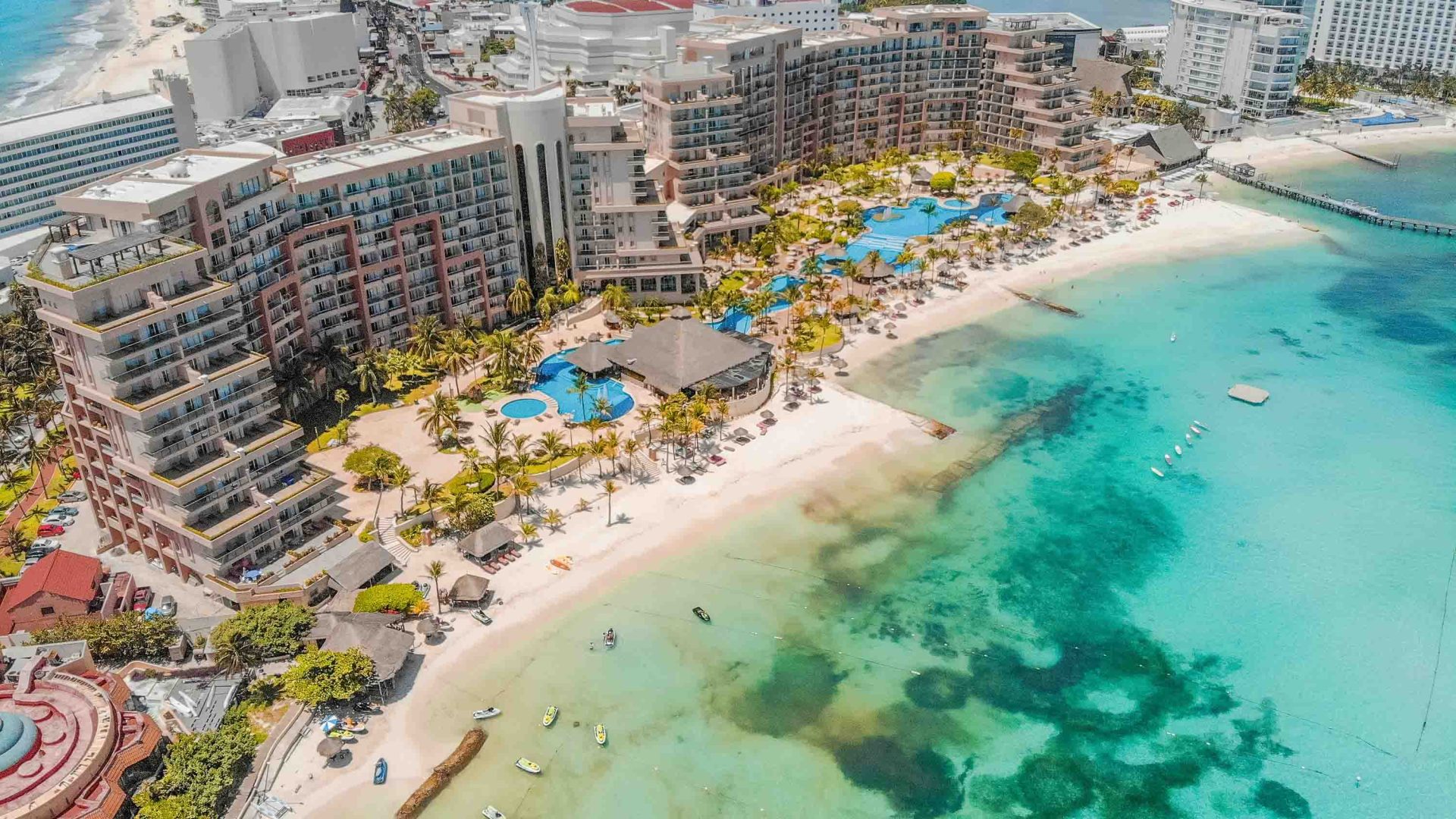 Hotels line a beach with bright blue water.