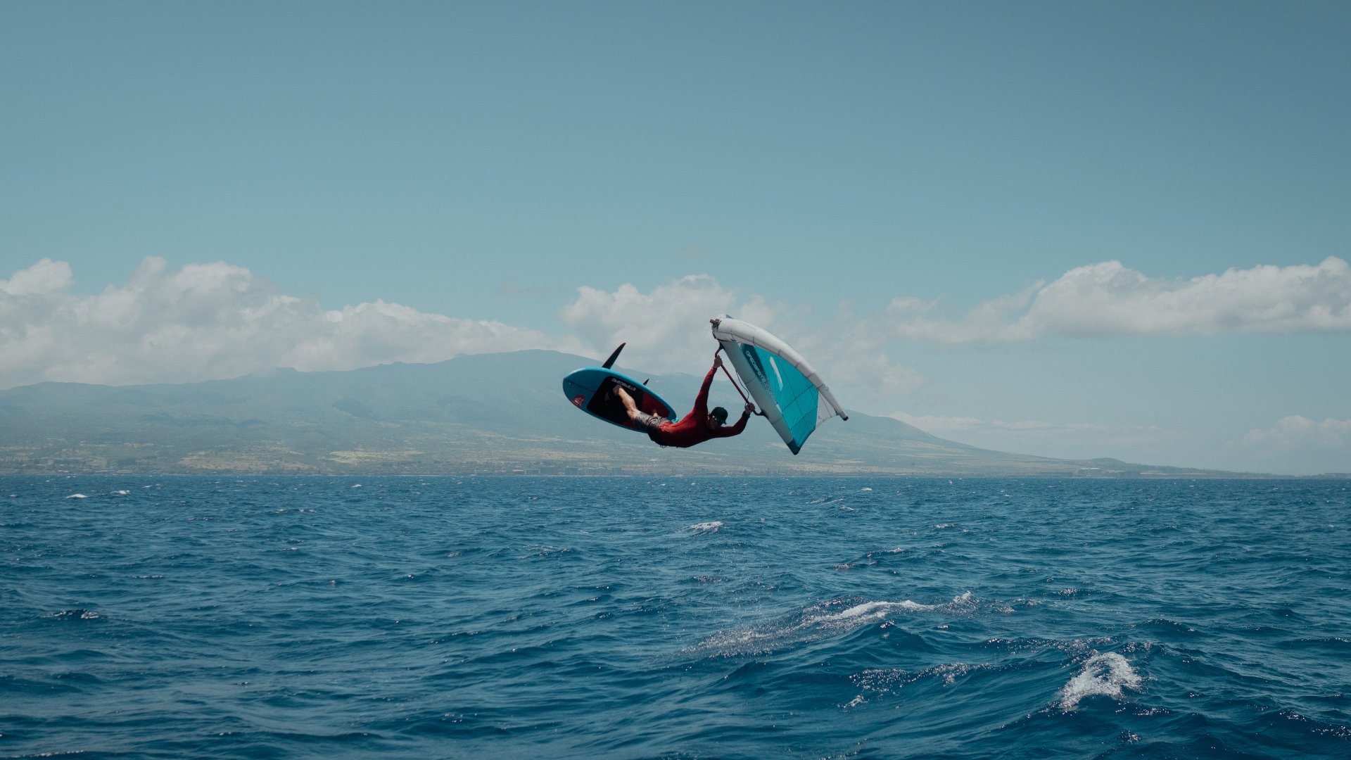 Man does air flip on hydrofoil with kite attached.