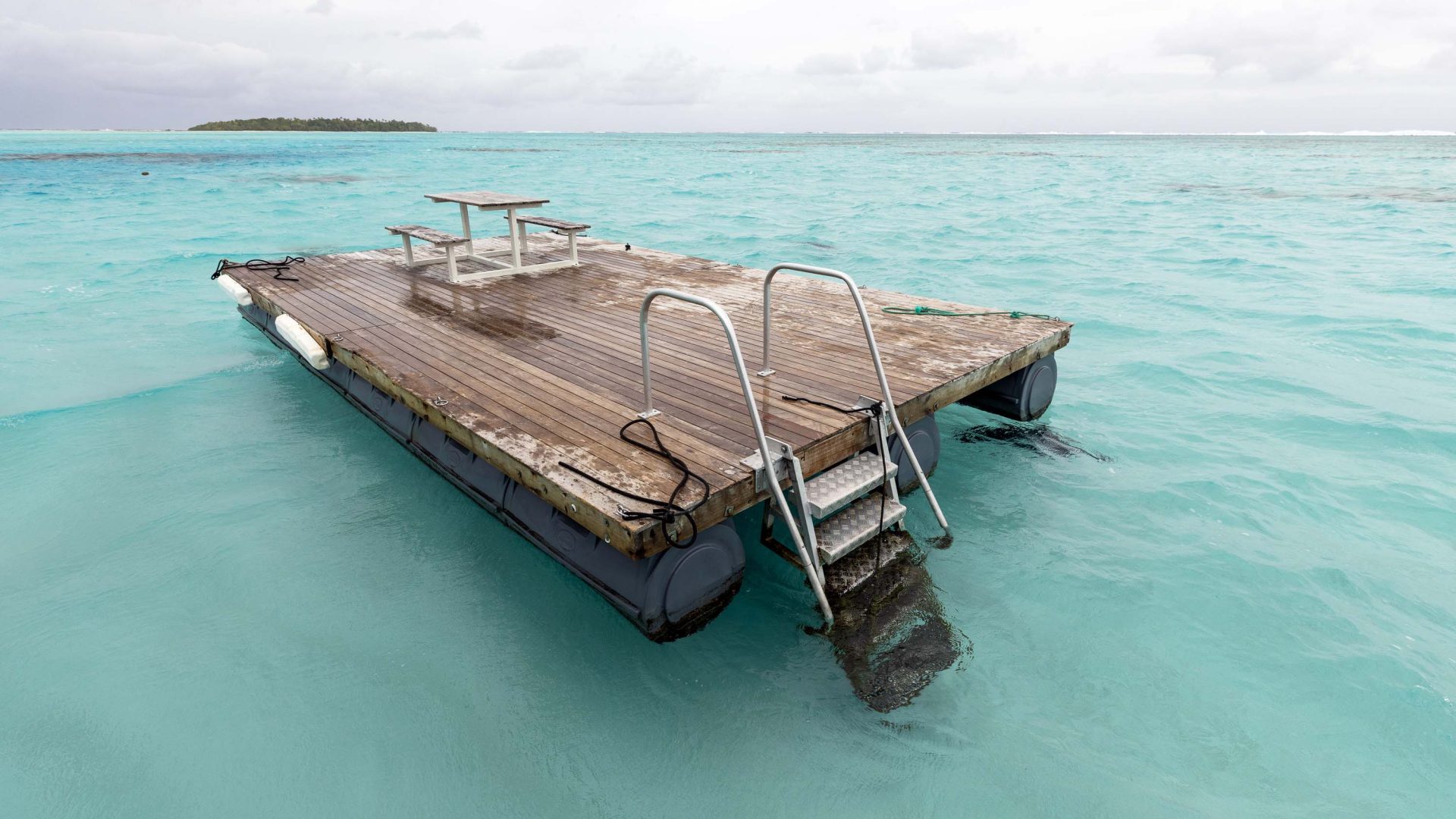 A wooden pontoon in turquoise water.