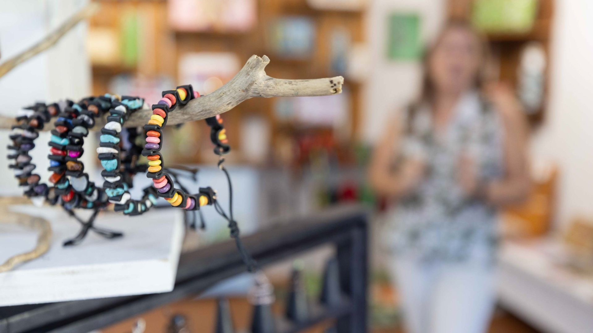 Bracelets on display with a softly focused woman in the background.