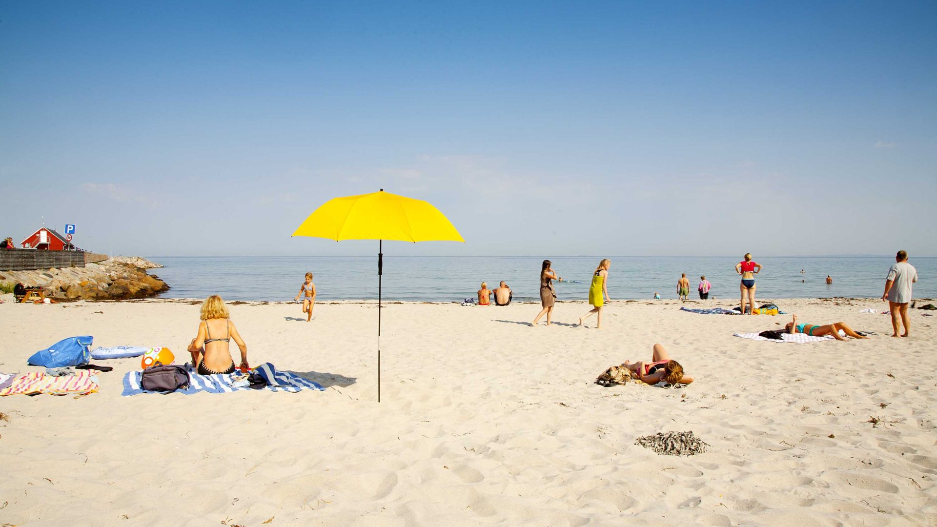 Many people at a beach on the sand.