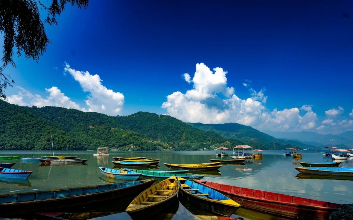 Canoes on shimmering blue lake against a blue sky