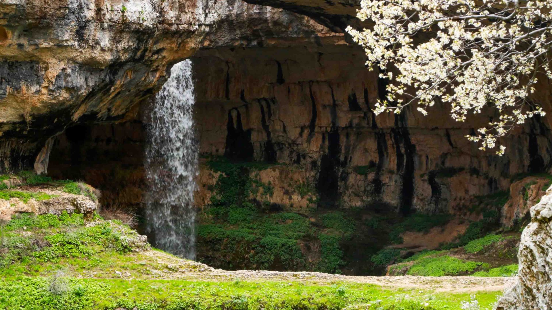 A waterfall comes through an opening in a gorge.