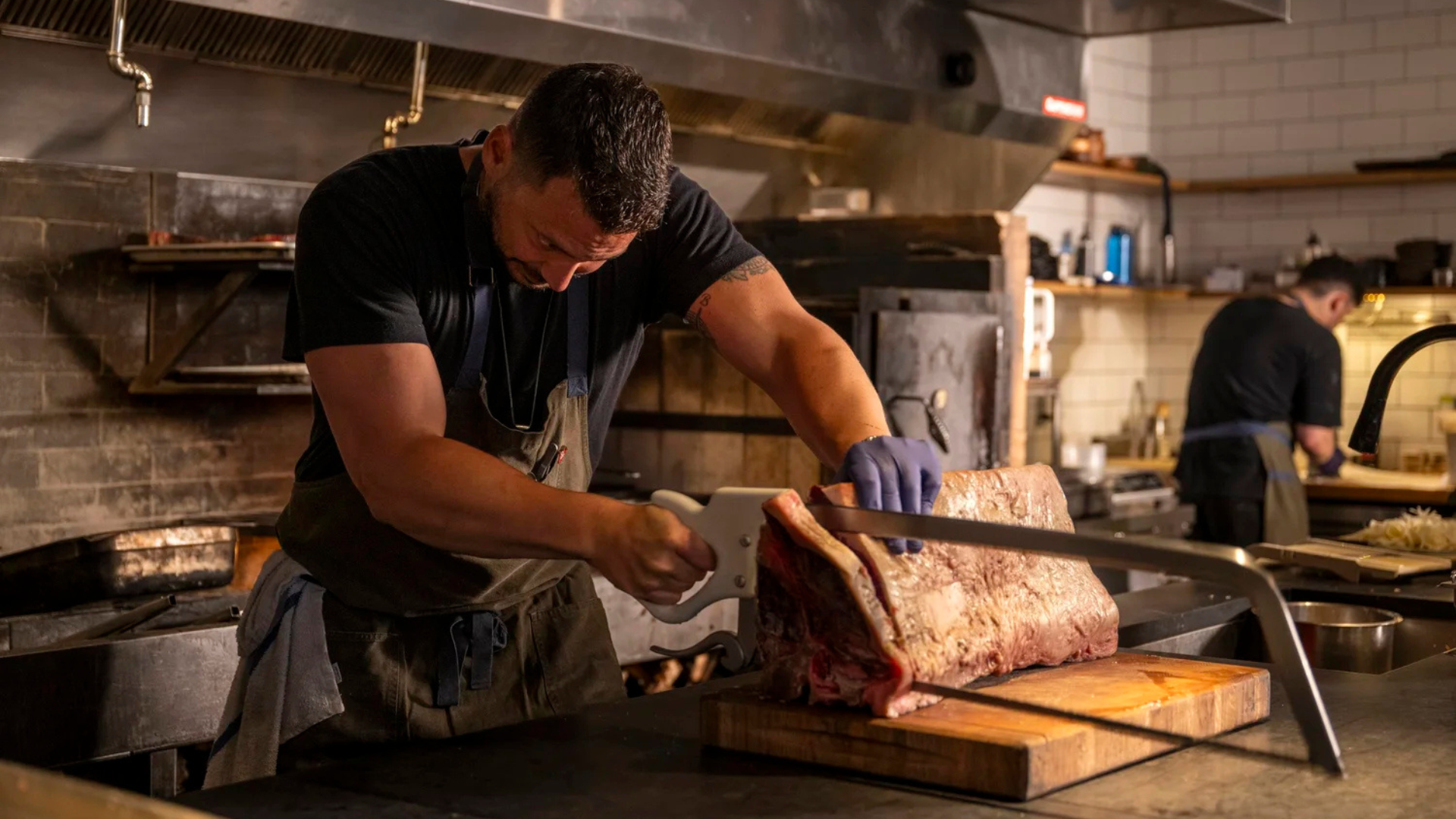Man carves large piece of meat