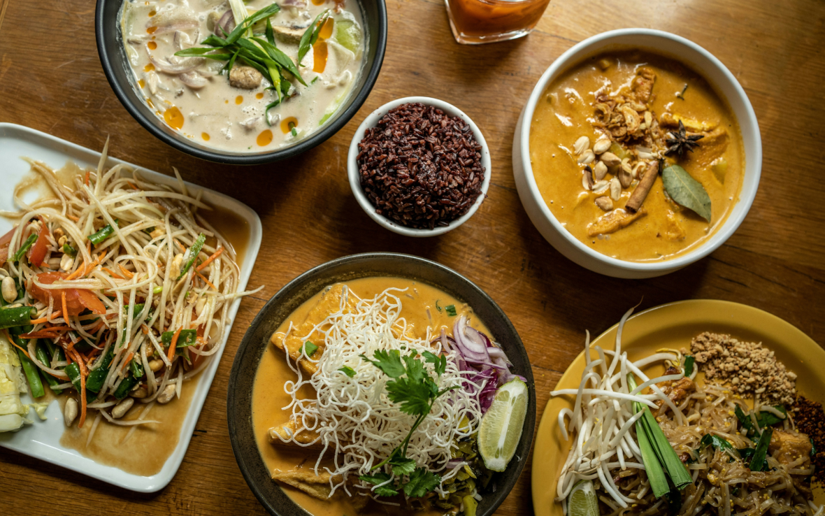 Six Thai dishes on wooden table