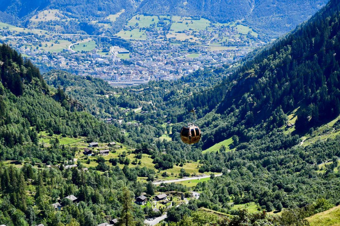 A gondola passes over hills and a valley.